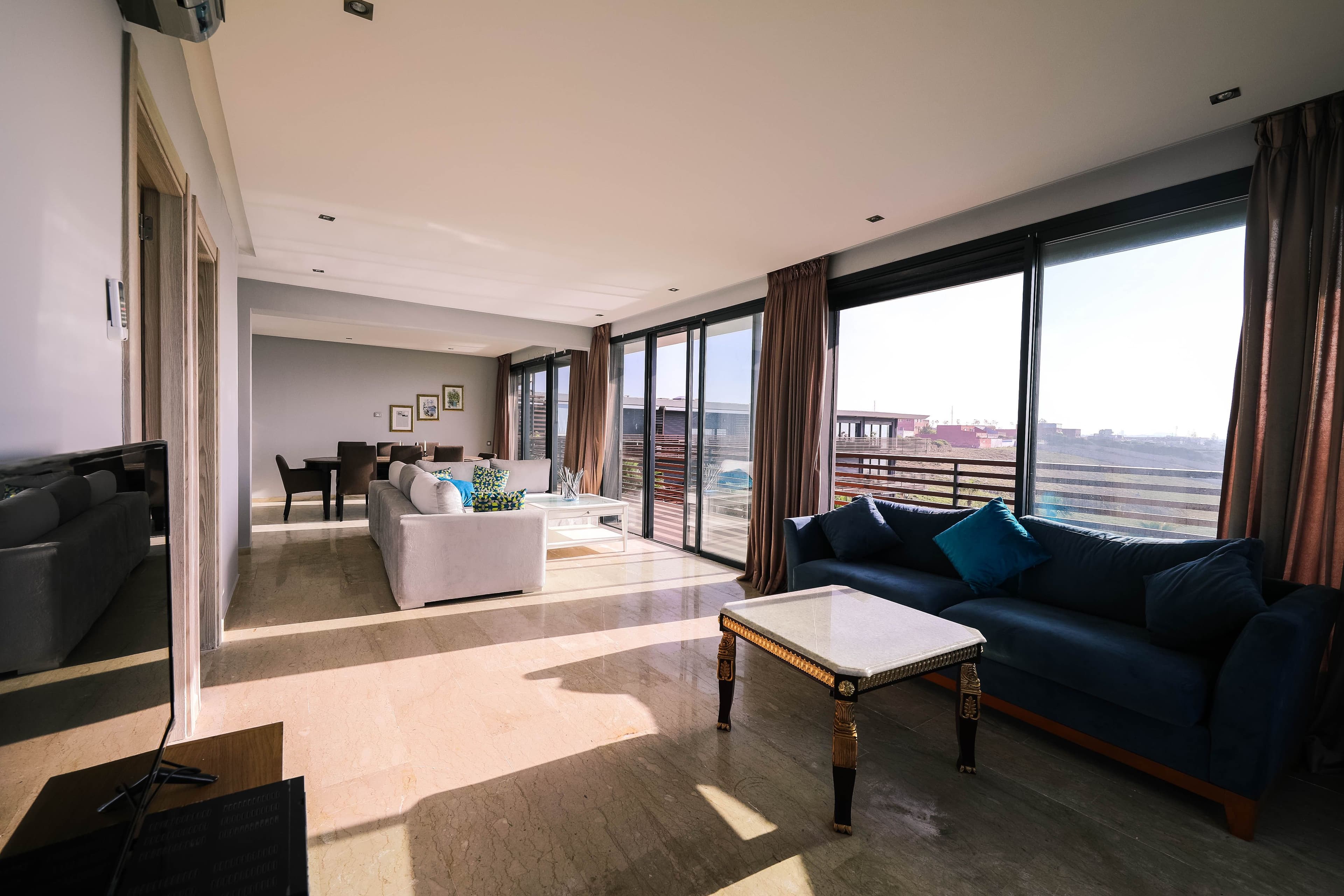 Sunlit modern living room with floor-to-ceiling windows and views — a Sydney short-stay property